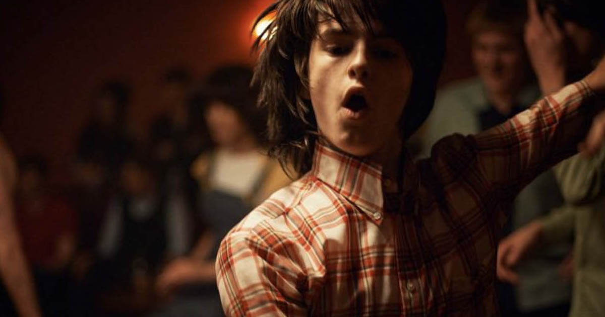 A young dancer in a checked shirt in a scene from Northern Soul.